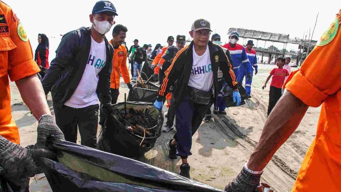 Peserta aksi gabungan relawan peduli lingkungan memungut sampah di kawasan Pantai Ujong Blang, Lhoksuemawe, Aceh, Minggu (16/2/2025). Aksi bersih dalam upaya menjaga laut bebas dari sampah plastik dan merawat kebersihan lingkungan kawasan pantai  tersebut dalam rangka menyambut HUT ke-53 Badan Nasional Pencarian dan Pertolongan (Basarnas). ANTARA FOTO/Rahmad/YU