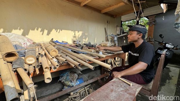 I Made Adi Wira Nata menunjukkan bambu yang digunakan untuk memproduksi seruling atau suling bambu. (Foto: I Nyoman Adhisthaya Sawitra/detikBali)