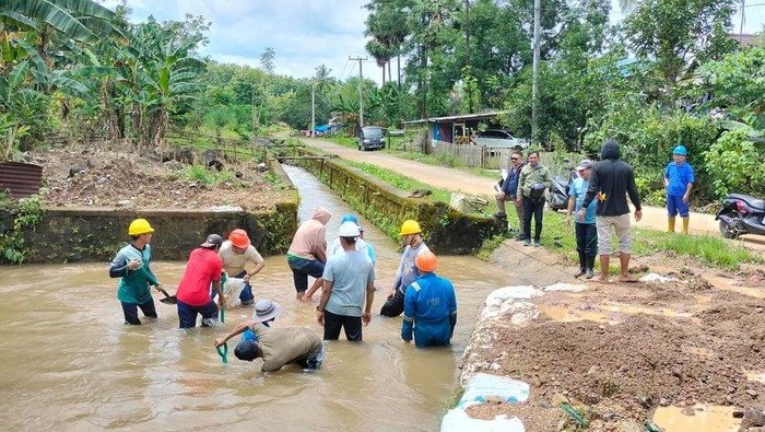 Petugas PDAM Makassar membersihkan sedimen lumpur di sungai Lekopancing.