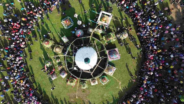 Panitia membagikan tempe saat ruwat desa di Lapangan Desa Sedenganmijen, Krian, Sidoarjo, Jawa Timur, Minggu (16/2/2025). Tradisi ruwat desa dengan membuat tumpeng tempe setinggi 12 meter yang diselenggarakan setiap tahun menjelang bulan suci Ramadhan tersebut menjadi ajang sedekah dan sebagai bentuk rasa syukur para perajin tempe kepada Tuhan YME atas limpahan rezeki. ANTARA FOTO/Umarul Faruq/YU
