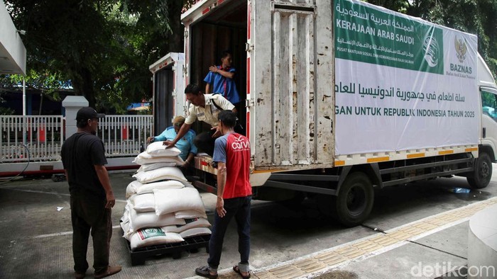 Warga menerima bantuan pangan untuk Ramadan di kawasan Kantor Baznas, Jakarta, Senin (17/2/2025).