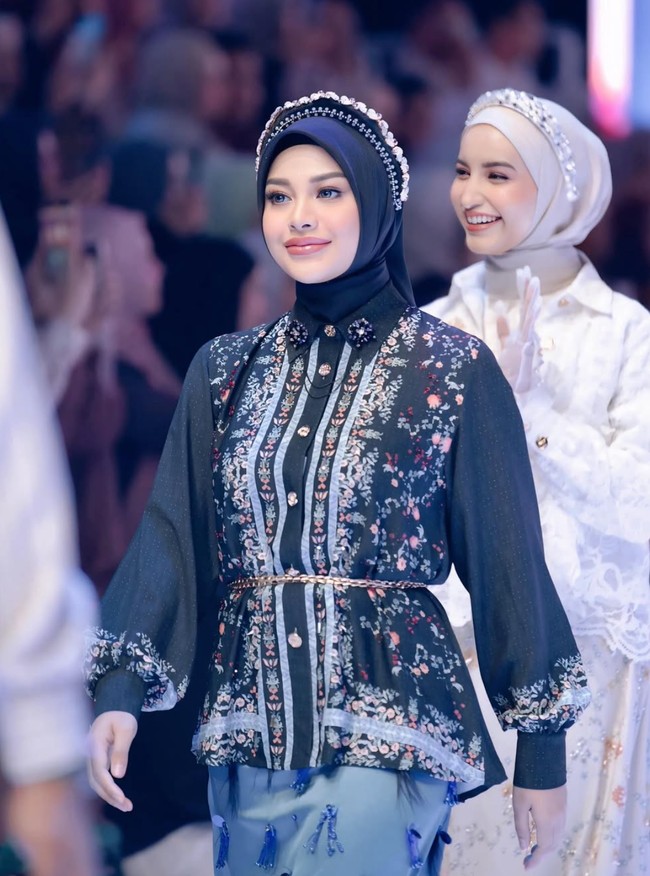 Melengkapi penampilannya, Aurel mengenakan hijab berwarna hitam dilengkapi dengan bando senada yang dipercantik dengan beads. Dengan penuh percaya diri, Aurel berlenggak-lenggok di atas panggung runway. Foto: Instagram/@aurelie.hermansyah