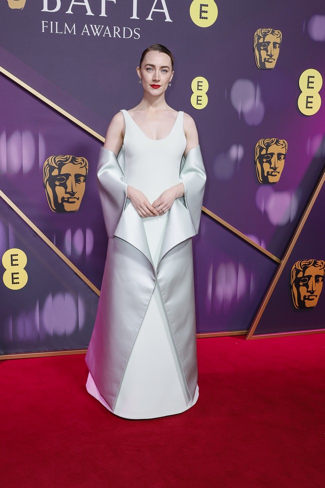 Pesona Saoirse Ronan sukses terpancar berkat gaun Louis Vuitton yang elegan dengan detail yang menyerupai origami. (Foto: Joel C Ryan/Invision/AP)