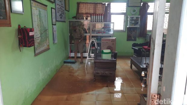 Guru membersihkan lumpur sisa banjir di Margorejo, Pati, Senin (17/2/2025).