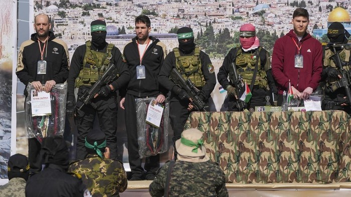 Israeli-American hostage  Sagui Dekel Chen, 36, left, and Israeli-Russian Alexander Troufanov, 29, are escorted by Hamas and Islamic Jihad fighters before being handed over to the Red Cross in Khan Younis, Gaza Strip, Saturday, Feb. 15, 2025. (AP Photo/Abdel Kareem Hana)