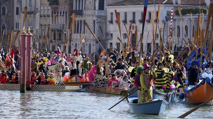 Boats sail during the traditional rowing parade, part of the historical Venice Carnival, in Venice, Italy, Sunday, Feb. 16, 2025. (AP Photo/Antonio Calanni)