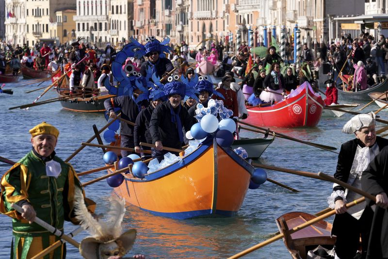 Boats sail during the traditional rowing parade, part of the historical Venice Carnival, in Venice, Italy, Sunday, Feb. 16, 2025. (AP Photo/Antonio Calanni)