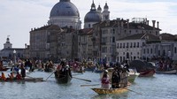 Perahu berlayar selama parade dayung tradisional di Venesia, Italia, Minggu (16/2/2025).