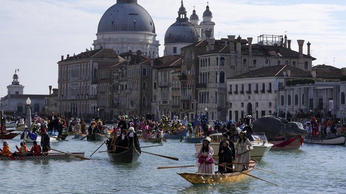 Boats sail during the traditional rowing parade, part of the historical Venice Carnival, in Venice, Italy, Sunday, Feb. 16, 2025. (AP Photo/Antonio Calanni)