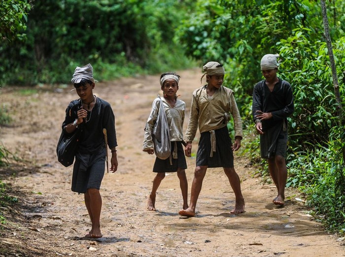 Larangan kunjungan wisatawan di Badui Dalam selama Kawalu Seorang bapak Suku Badui Dalam ditemani anaknya memikul durian hasil panen untuk dijual di Cijahe, Lebak, Banten, Minggu (16/2/2025). Pemerintah adat Suku Badui menutup kawasan wisata Budaya Badui Dalam untuk tidak dikunjungi wisatawan karena adanya gelaran ritual adat Kawalu secara tertutup selama tiga bulan yang dilaksanakan pada 1 Februari hingga 3 Mei 2025. ANTARA FOTO/Muhammad Bagus Khoirunas/Spt.