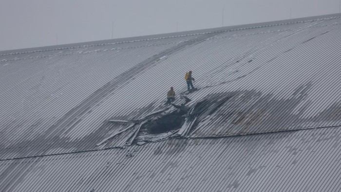 Penampakan Kubah Pelindung PLTN Chernobyl Rusak Dihantam Drone Rusia Rescuers work at the New Safe Confinement (NSC) structure, that covers the old sarcophagus which confines the remains of the damaged fourth reactor and bears an impact of what Ukrainian President Volodymyr Zelenskiy says was a Russian drone strike, amid Russia's attack on Ukraine, at the Chornobyl Nuclear Power Plant, in Kyiv region, Ukraine February 14, 2025. REUTERS/Gleb Garanich