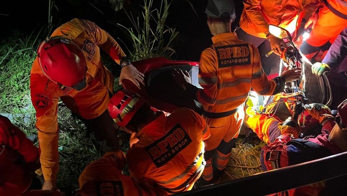 Tim SAR gabungan mengevakuasi motor ditumpangi ibu dan anak terjun ke jurang Jl Raya Cilebut Bogor. Foto: Dok. istimewa.