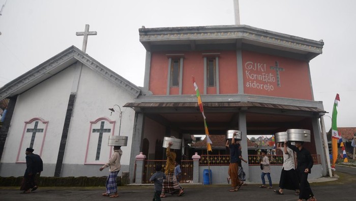 Sejumlah warga membawa tenong berisi makanan saat melintas diantara gereja dan masjid saat mengikuti Tradisi Sadranan di lereng Gunung Merbabu, Sidorejo, Ginting, Cepogo, Boyolali, Jawa Tengah, Senin (17/2/2025). Tradisi Sadranan yang telah dilakukan turun temurun pada bulan Ruwah penanggalan Jawa tersebut diikuti oleh warga beragama Kristen dan Islam untuk bersama-sama mendoakan para leluhur yang telah meninggal dunia sekaligus sebagai wujud kerukunan antarumat beragama melalui kegiatan tradisi budaya Jawa. ANTARA FOTO/Aloysius Jarot Nugroho/nym.