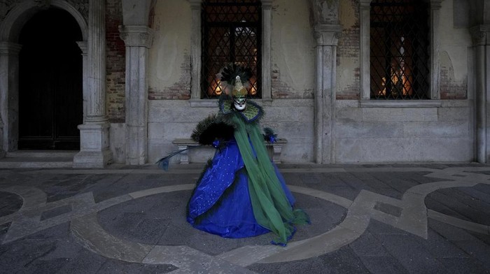 A woman wears mask in St. Marks square during the historical Venice Carnival, in Venice, Italy, Sunday, Feb. 16, 2025. (AP Photo/Antonio Calanni)