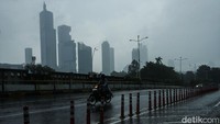 Pengendara melintas di kawasan Kuningan, Jakarta, yang diguyur hujan, Selasa (18/2/2025).