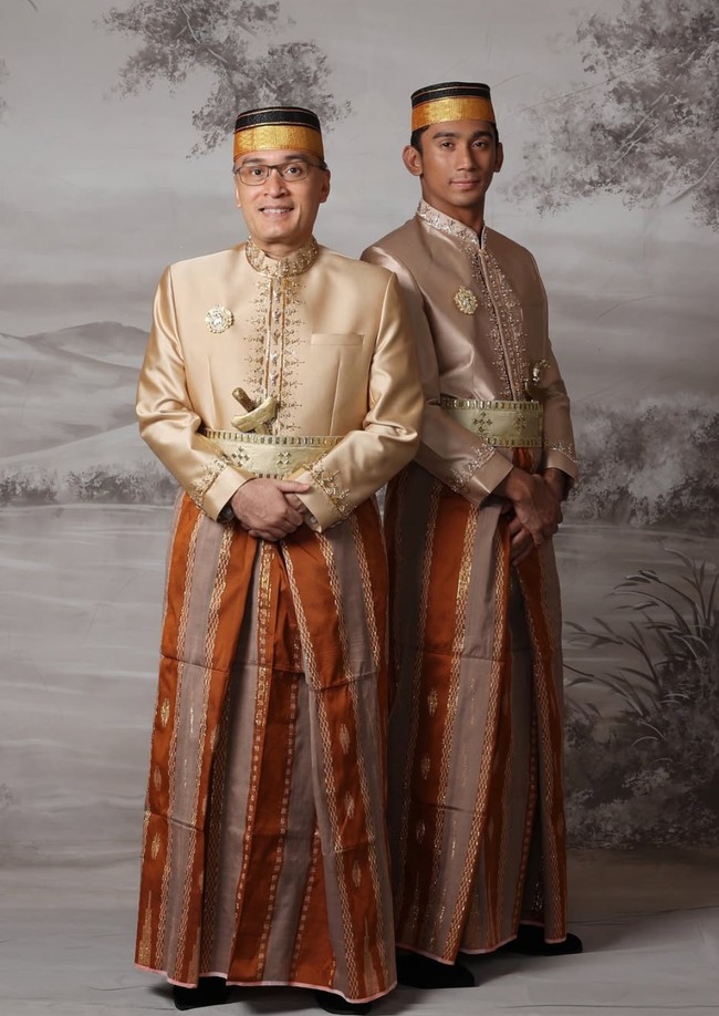 Suami dan putra Marini, Daffa Wardhana, tampil mengenakan jas tutu berwarna coklat keemasan dipadukan dengan kain sarung. Melengkapi penampilannya, keduanya juga memakai penutup kepala khas pria adat Bugis. Foto: Instagram/@marinizumarnisreal