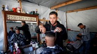 Warga Gaza antre untuk potong rambut. 