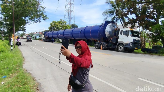 Warga berfoto di depan truk Optimus Prime yang terparkir di pinggir di pinggir Jalan Raya Karanganyar-Kebumen tepatnya di Desa Jatiluhur, Kecamatan Karanganyar pada Selasa (18/2/2025) sore.