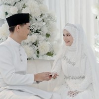 Yasmine dan suaminya tampil dalam balitan busana serba putih. Demikian pula dengan dekorasinya yang bertabur dengan bunga-bunga yang juga bernuansa putih. Foto: Instagram/@yxsmine.ow