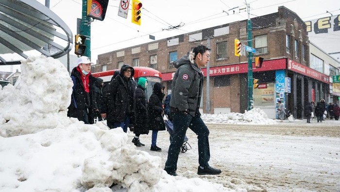 Badai Musim Dingin yang Parah Melanda Kanada People walk down a snow covered street during a snowstorm in Toronto, Ontario, Canada February 15, 2025. REUTERS/Arlyn McAdorey