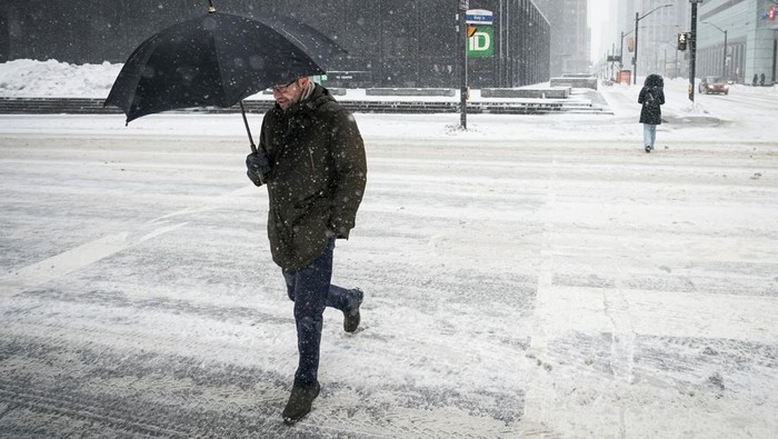 Badai Musim Dingin yang Parah Melanda Kanada People walk down a snow covered street during a snowstorm in Toronto, Ontario, Canada February 15, 2025. REUTERS/Arlyn McAdorey