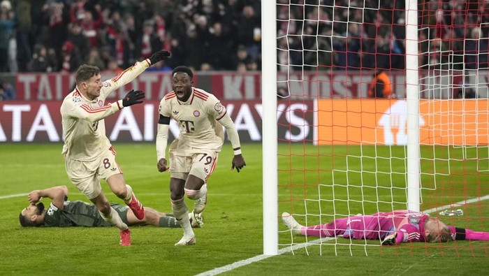 Bayerns Alphonso Davies, centre, celebrates after scoring his sides opening goal during the Champions League playoff second leg soccer match between FC Bayern Munich and Celtic Glasgow at the Allianz Arena in Munich, Germany, Tuesday, Feb. 18, 2025. (AP Photo/Matthias Schrader)