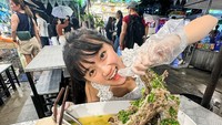 Ini ada momen kulinernya di pasar malam Thailand, JODD Fairs. Ia menikmati olahan daging berukuran jumbo dan air kelapa. Foto: Instagram @cgulla