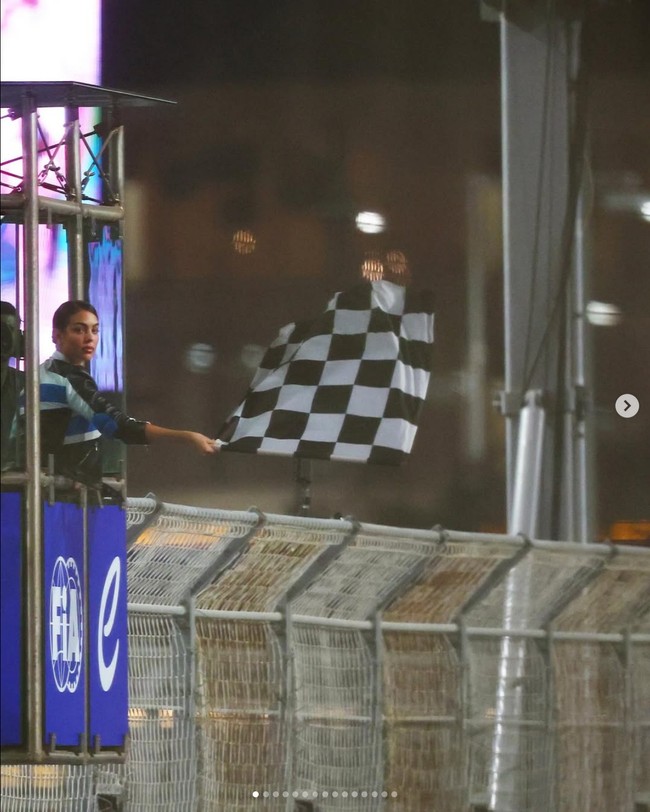 Menjadi tamu istimewa, Georgina Rodriguez pun diberi tugas spesial. Dia mendapat kesempatan untuk mengibarkan bendera kotak-kotak saat pembalap tim DS Penske asal Jerman, Maximilian Günther, melintasi garis finis dan memenangkan balapan. Foto: Dok. Instagram Georgina Rodriguez