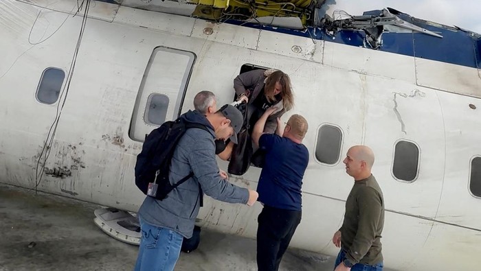 Passengers leave a Delta Air Lines CRJ-900 jet after it crashed on landing at Toronto Pearson International Airport in Mississauga, Ontario, Canada February 17, 2025 in a still image from video.  Peter Koukov/Handout via REUTERS  THIS IMAGE HAS BEEN SUPPLIED BY A THIRD PARTY