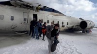 Penumpang meninggalkan jet Delta Air Lines CRJ-900 yang terbalik saat mendarat di Bandara Internasional Toronto Pearson di Mississauga, Ontario, Kanada, Senin (17/2/2025). (REUTERS/Peter Koukov)  