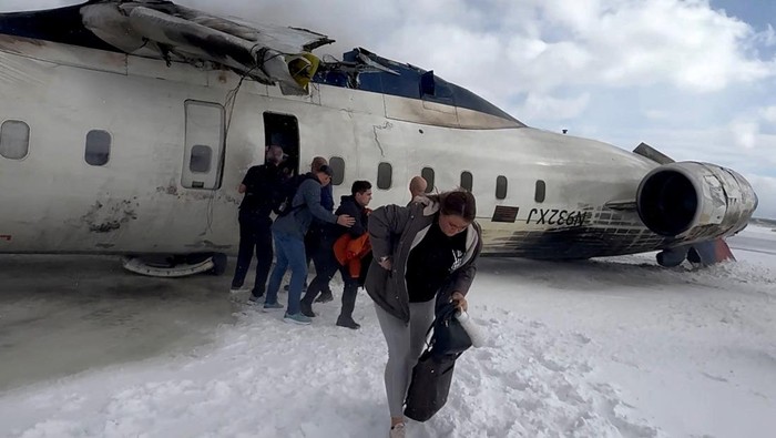 Passengers leave a Delta Air Lines CRJ-900 jet after it crashed on landing at Toronto Pearson International Airport in Mississauga, Ontario, Canada February 17, 2025 in a still image from video. Peter Koukov/Handout via REUTERS THIS IMAGE HAS BEEN SUPPLIED BY A THIRD PARTY