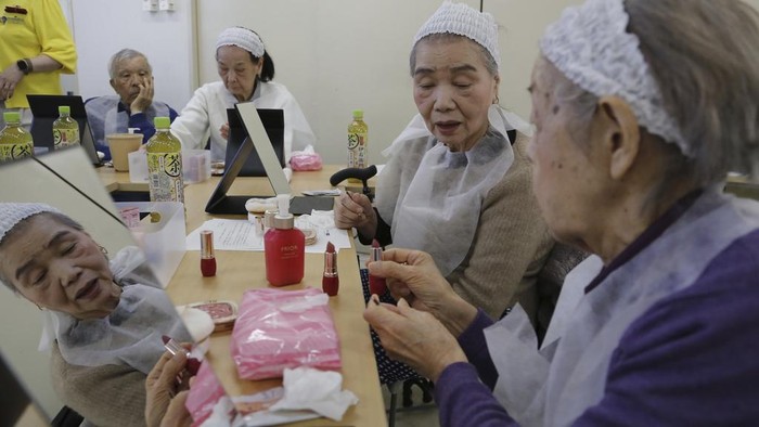Participants try on makeup at a special class at a Tokyo housing complex that teaches people to stay healthy and beautiful, on Feb. 14, 2025. (AP Photo/Yuri Kageyama)