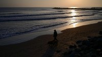Pemandangan menunjukkan seorang pria berjalan di garis pantai Teluk Meksiko di Boca del Rio, negara bagian Veracruz, Meksiko, Selasa (18/2/2025). Baru-baru ini Trump secara sepihak meminta Google untuk mengubah nama Teluk Meksiko menjadi Teluk Amerika.