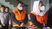Keduanya telah mengenakan rompi oranye dengan tangan terborgol. Setelah itu, mereka memasuki ruang konferensi pers.