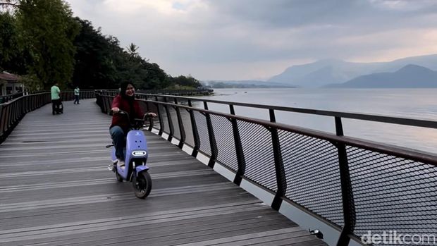 Pengunjung saat berkeliling di Waterfront City Pangururan menggunakan sepeda listrik. (Foto: Kartika Sari/detikSumut).