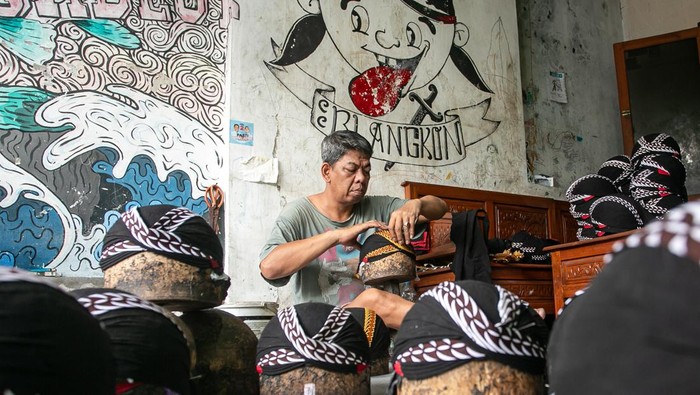 Perajin menyelesaikan pembuatan kerajinan blangkon di kampung Potrojayan, Serengan, Solo, Jawa Tengah, Rabu (19/2/2025). Menurut data Bank Indonesia (BI) oustanding kredit UMKM pada Desember 2024 hanya tumbuh 3 persen atau melambat dari bulan sebelumnya yang mencapai 4 persen, sektor usaha UMKM pada tahun 2024 mengalami kelesuan hal ini berdasarkan oustanding kredit yang menurun dengan rasio kredit bermasalah atau non performing loan (NPL) yang tetap tinggi. ANTARA FOTO/Mohammad Ayudha/Spt.