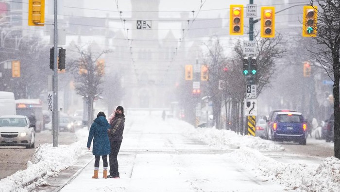 People walk down a snow covered street during a snowstorm in Toronto, Ontario, Canada February 15, 2025.  REUTERS/Arlyn McAdorey