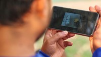 Seorang warga negara Pakistan yang diperdagangkan untuk bekerja di pusat penipuan di Myanmar selama satu bulan dan dikirim ke Thailand pada 12 Februari, menonton klip video penyiksaan yang direkam di dalam pusat penipuan di tempat penampungan di dalam Distrik Militer ke-310 (Benteng Wachiraprakan), di provinsi Tak, Thailand, Rabu (19/2/2025).