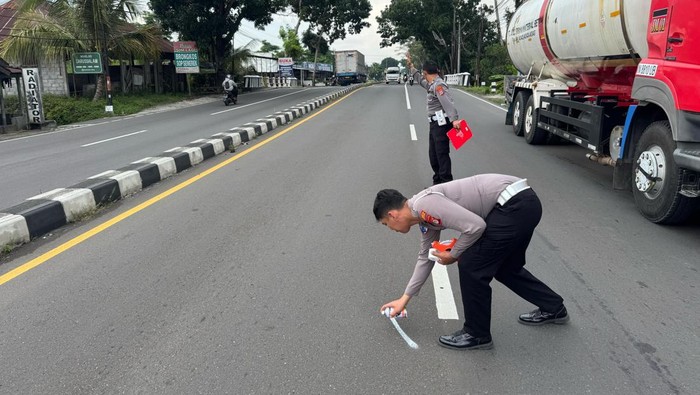 Petugas olah TKP lokasi kecelakaan motor membentur truk di Jalan Magelang, Sleman, Rabu (19/2/2025).