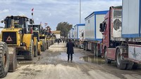 Buldoser dan truk pengangkut rumah semipermanen menunggu untuk memasuki Gaza di perbatasan Rafah antara Mesir dan Jalur Gaza, Selasa (18/2/2025). (AP Photo/Mohamed Arafat)