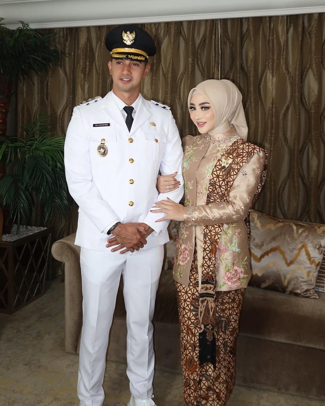 Ali Syakieb tampil gagah mengenakan pakaian dinas upacara (PDU) berupa setelan jas putih dan dasi hitam, lengkap dengan topi dinas berlambang Garuda emas. Foto: Instagram/@marginw