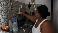 Seorang warga menunjukkan bahwa kehabisan air di rumah di tengah gelombang panas ekstrem di daerah kumuh Jacarezinho di Rio de Janeiro, Brasil. Menurut kepala ahli meteorologi kota, Raquel Franco, suhu di Rio de Janeiro mencapai rekor tertinggi 44 derajat Celcius.