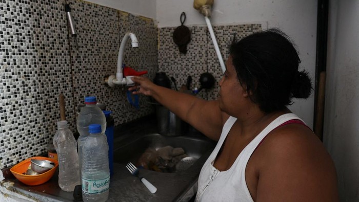Brasil Krisis Air Saat Suhu Tembus 44 Derajat Celcius A worker carries empty gallons at a water gallons store as several neighborhoods run out of water, amid a extreme heatwave, in Rio de Janeiro, Brazil February 19, 2025. REUTERS/Aline Massuca