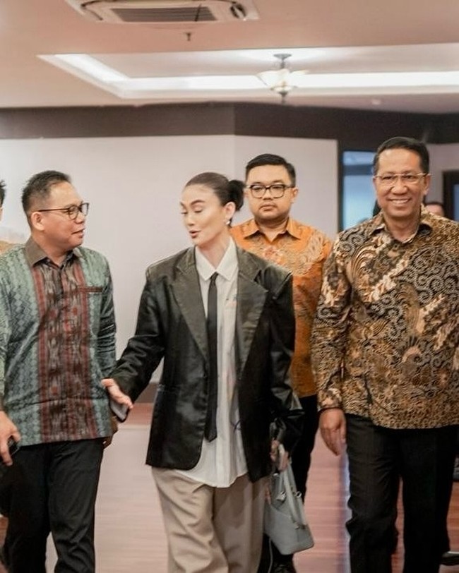 Biasa berbusana seksi yang terbuka, Agnez Mo kali ini mengandalkan satu set busana serba longgar. Untuk atasan, ia mengandalkan kemeja putih yang dibungkus blazer kulit hitam nan edgy.  (Foto: Instagram/@agnezmo)