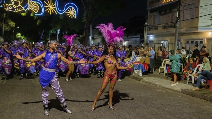 A candombe dancer performs with the public during a Carnival parade in Montevideo, Uruguay, Wednesday, Feb. 19, 2025. (AP Photo/Matilde Campodonico)