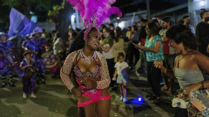 A candombe dancer performs with the public during a Carnival parade in Montevideo, Uruguay, Wednesday, Feb. 19, 2025. (AP Photo/Matilde Campodonico)