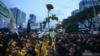 Selain membawa poster kritikan, ada sebagian peserta aksi yang membawa bunga.