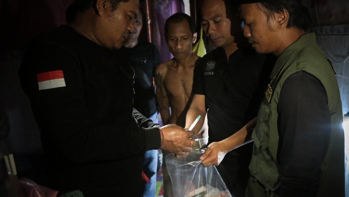 Personel kepolisian mengamankan barang bukti dari kamar terduga pengedar narkoba saat penggerebekan di Dasan Agung, Mataram, NTB, Kamis (20/2/2025). Dalam giat aparat gabungan yang terdiri dari unsur TNI, Polri, dan BNN di Dasan Agung yang masuk dalam wilayah rawan peredaran narkoba tersebut diamankan delapan warga beserta barang bukti yang ada kaitan dengan narkoba jenis sabu. ANTARA FOTO/Dhimas Budi Pratama/sgd/rwa.