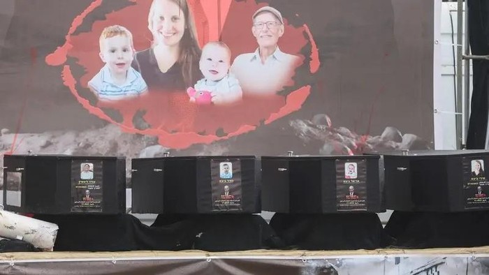 Coffins are placed on stage during the handover of deceased hostages Oded Lifschitz, Shiri Bibas and her two children Kfir and Ariel Bibas, seized during the deadly October 7, 2023 attack, to the Red Cross, as part of a ceasefire and hostages-prisoners swap deal between Hamas and Israel, in Khan Younis in the southern Gaza Strip, February 20, 2025. (Reuters)