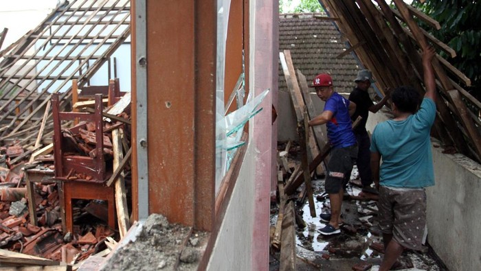 Pekerja membersihkan reruntuhan atap ruang kelas yang ambruk di SMP Islam Al Amin, Malang, Jawa Timur, Kamis (20/2/2025). Atap ruang kelas di sekolah tersebut ambruk sebab tak kuat menahan derasnya hujan dan mengakibatkan sebanyak 210 siswa dari enam kelas sementara menjalani proses belajar mengajar secara daring. ANTARA FOTO/Ari Bowo Sucipto/rwa.